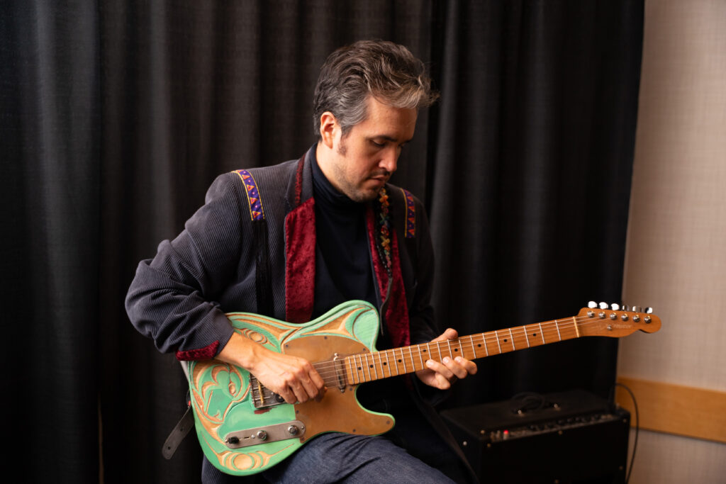 Cowichan muiscian Aidan thorne playing is hand-carved guitar