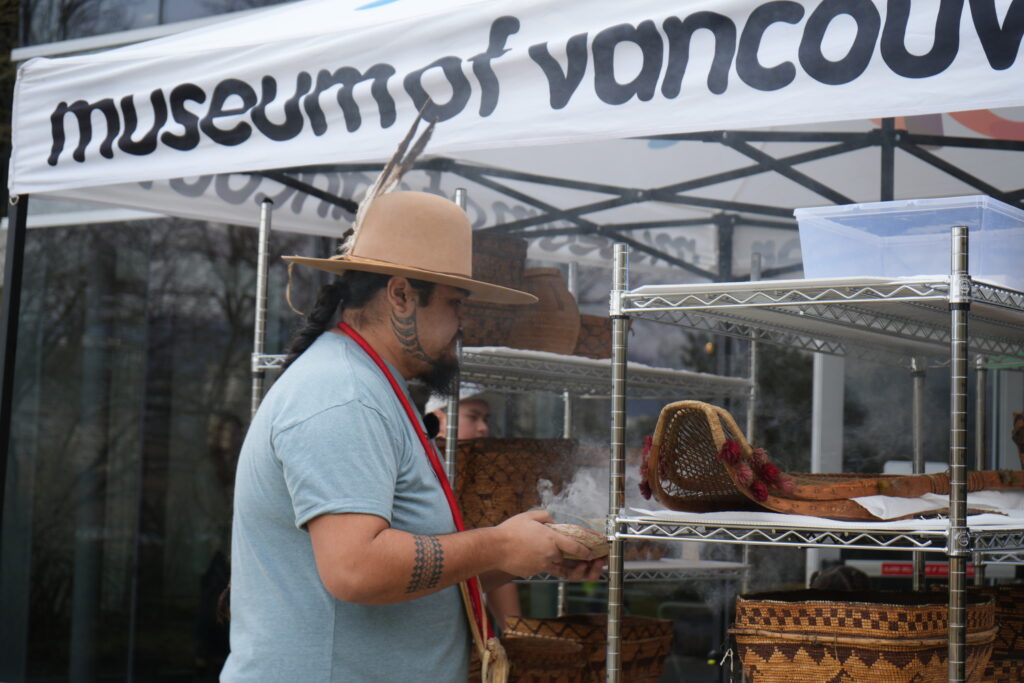 A person uses smoke to smudge items on a shelf