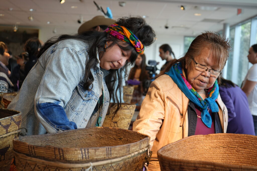 Two people look closely at the baskets